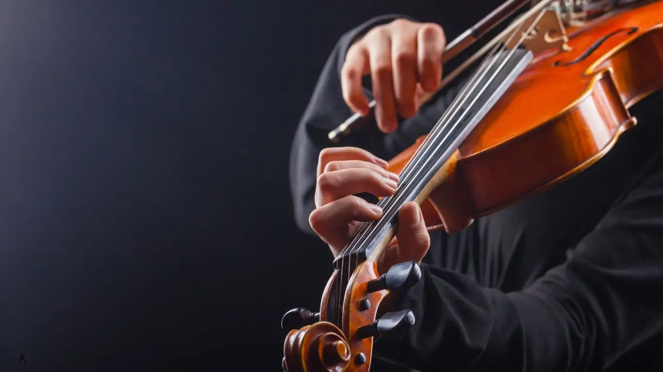 Violino e arco sobre fundo escuro